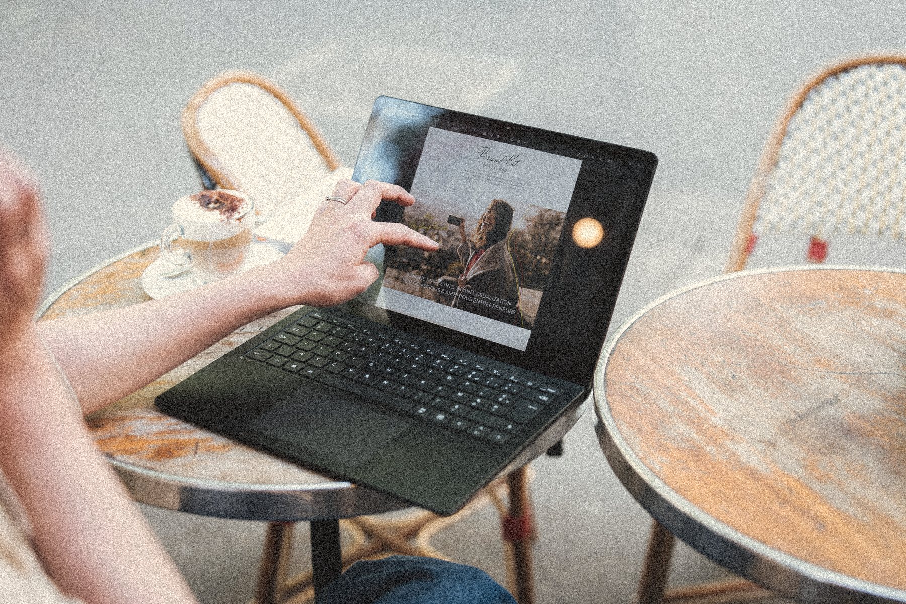 Aliya's hands on a laptop at a Paris café table