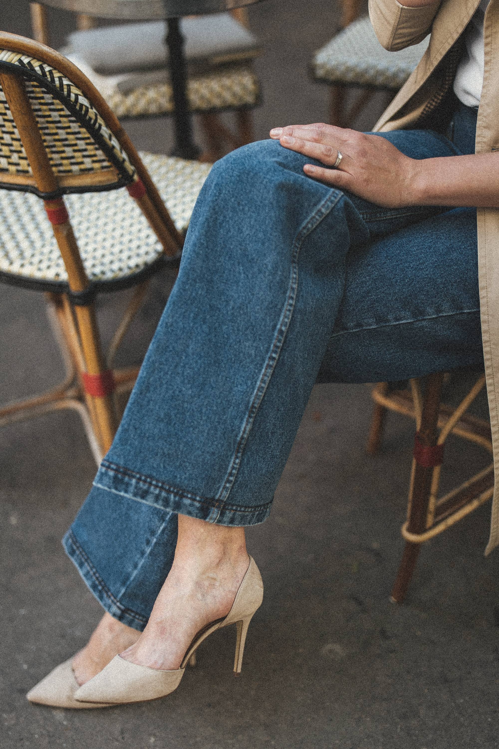 Aliya's legs crossed in heels at a Paris café table